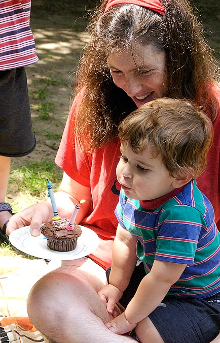Anne and Noah blowing out his birthday candles (2 yrs old); Decordova Museum, Lincoln, MA; ; Nikon D1X; 7/14/2002 11:58:06.4 AM; Color; Data Format: RAW (12-bit); Compression: None; Image Size: Large (3008 x 1960); Lens: 28-105mm f/3.5-4.5; Focal Length: 60mm; Exposure Mode: Aperture Priority; Metering Mode: Multi-Pattern; 1/125 sec - f/8; Exposure Comp.: +2/3 EV; Exposure Difference: 0 EV; Flash Sync Mode: Not Attached; Sensitivity: ISO 800; Color Mode: Mode II (Adobe RGB); Hue Adjustment: 3; White Balance: Direct sunlight; Tone Comp: Less Contrast; Sharpening: Normal