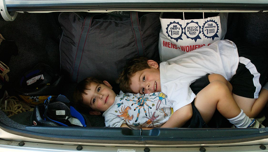 Noah and Eytan packing themselves in the car,; preparing for NH vacation.  Eytan helped Noah into the trunk and then climbed in.