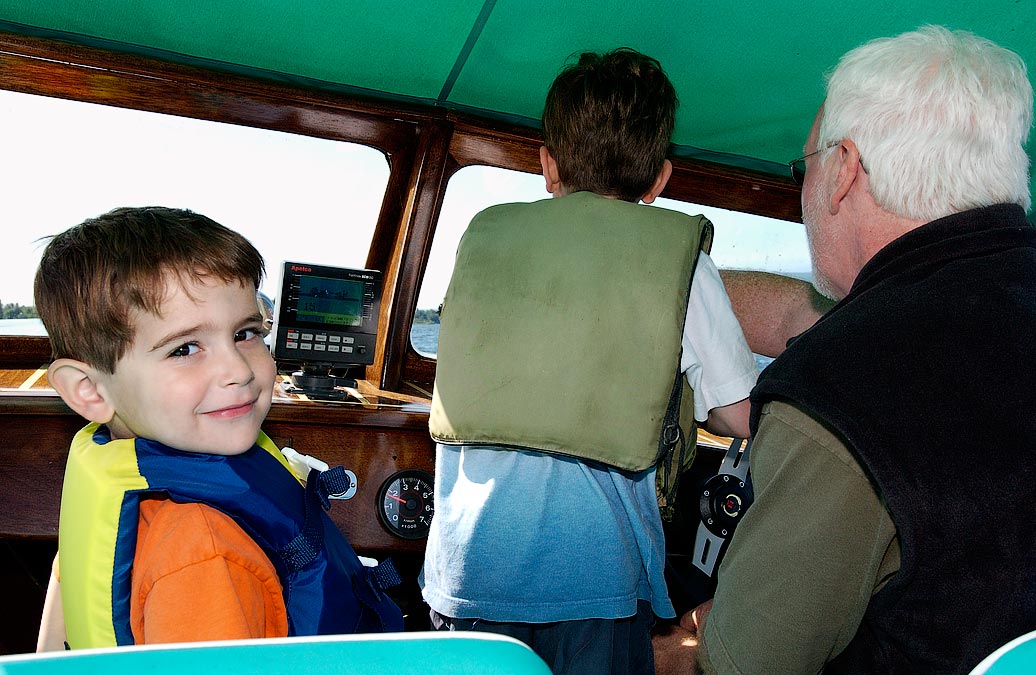 L-R: First Mate Noah, Captain Eytan and Peter drive Peter\'s motor boat on Lake Champlain