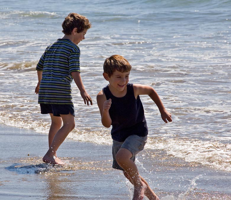 Eytan and Noah running from waves; Beach south of Cannon Beach; OR; US