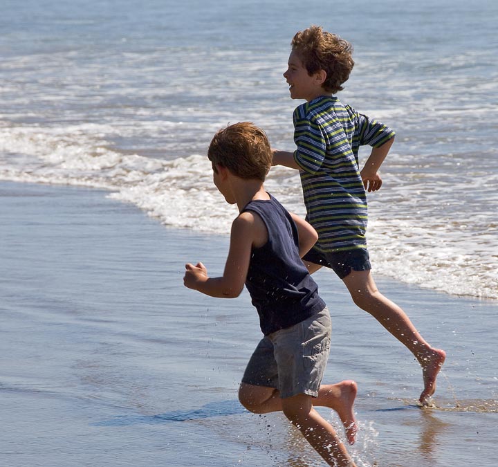 Eytan and Noah running from waves; Beach south of Cannon Beach; OR; US