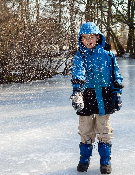 On the ice; Eytan collecting and throwing snow; Frog Pond at Habitat; Belmont; MA; US