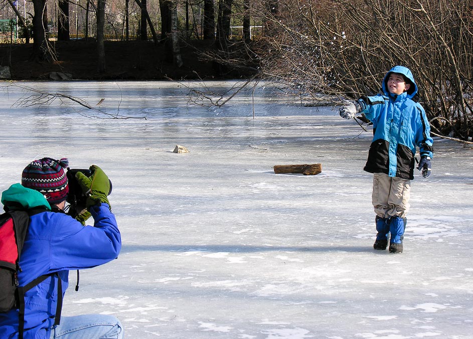On the ice; Eytan collecting and throwing snow; Frog Pond at Habitat; Belmont; MA; US