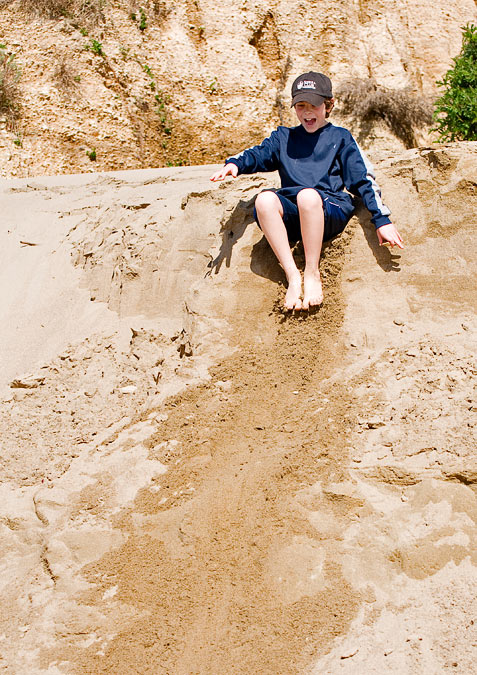 Eytan sliding down sand dunes; Point Reyes; CA; US
