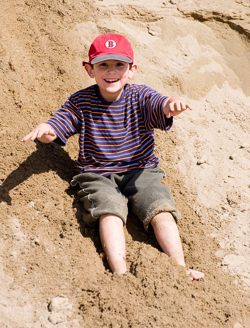 Noah sliding down sand dunes; Point Reyes; CA; US