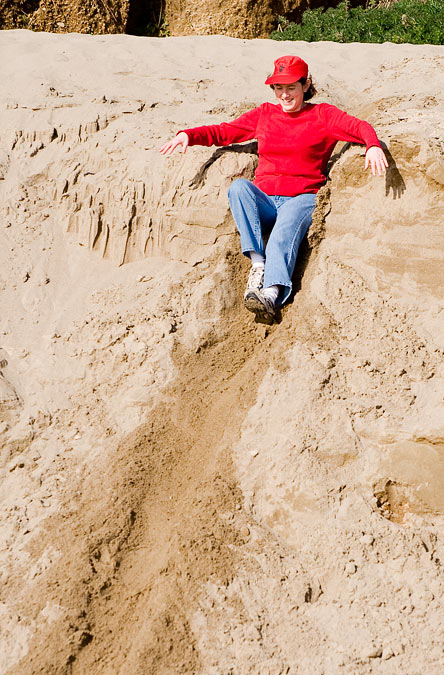 Anne sliding down a sand dune; Point Reyes; CA; US