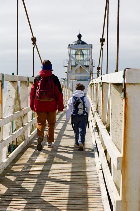 Anne and Noah walking across the bridge to the Point Bonitas Lighthouse.  Only 2 people are allowed on the bridge at a time, giving the tourists a warm fuzzy feeling about the bridge.; Point Bonita Lighthouse; Golden Gate National Recreation Area; CA; US