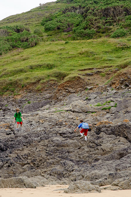 Eytan and Noah climbing on the rocks; Three Cliffs Bay, Gower; MA; Wales
