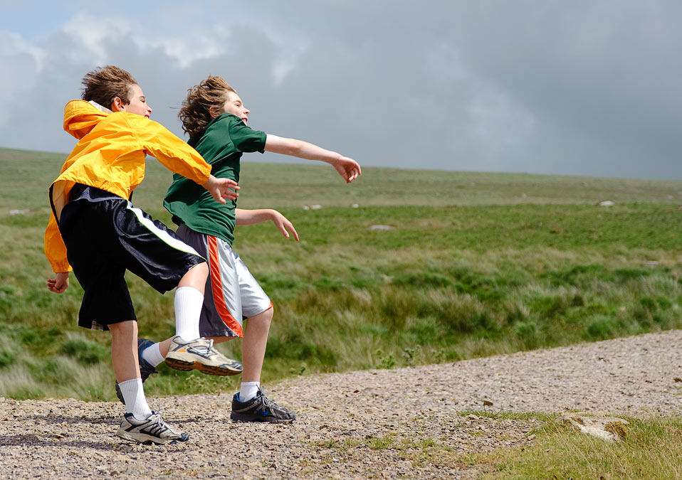 Noah and Eytan throwing rocks; Dartmoor; Devon; England