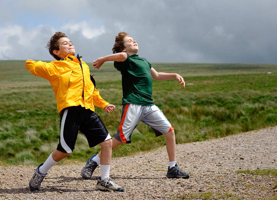 Noah and Eytan throwing rocks; Dartmoor; Devon; England